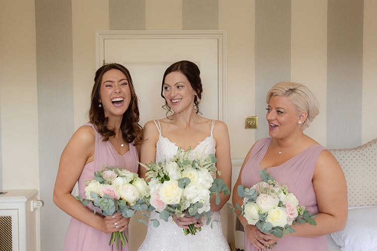 Bride and Bridesmaids laughing.