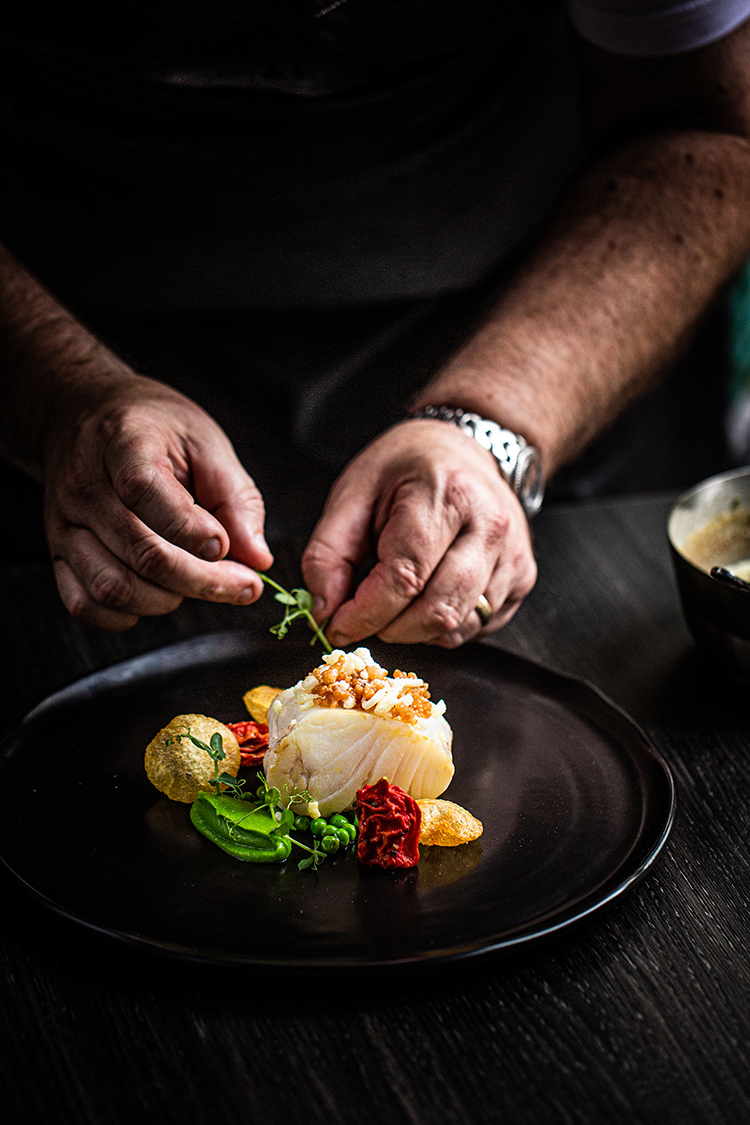 Chef finishing off a dish at Craft Dining