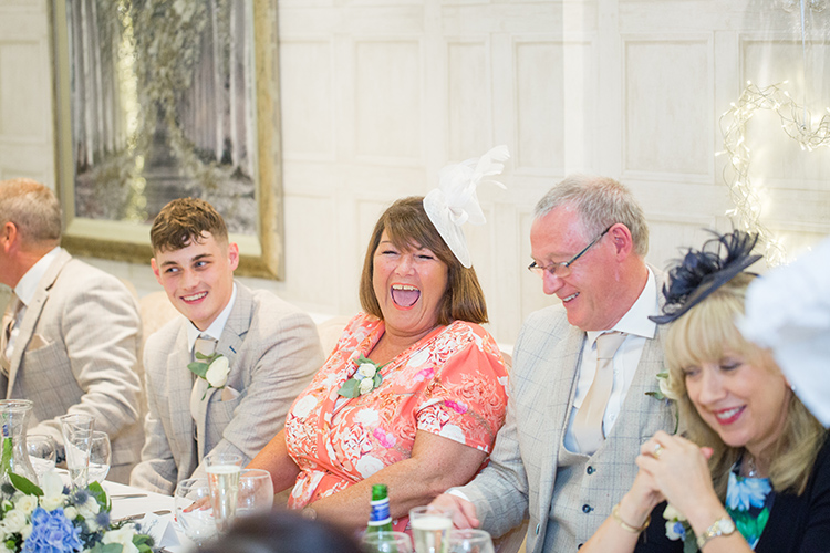 Bride and Groom in Nuthurst Grange's gardensWedding guest laughing