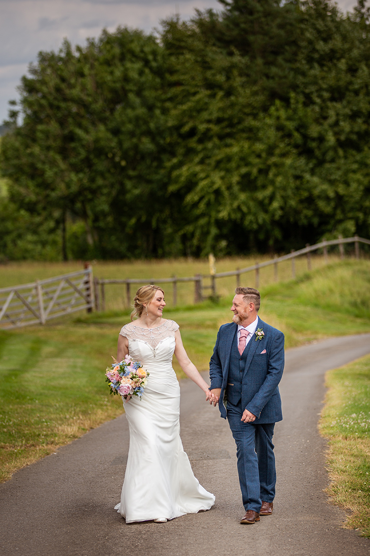 bride and groom walking up the lane