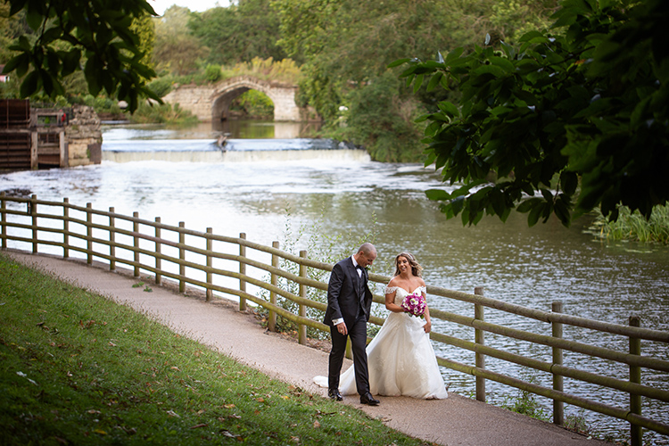 Bride and Groom walking by river.
